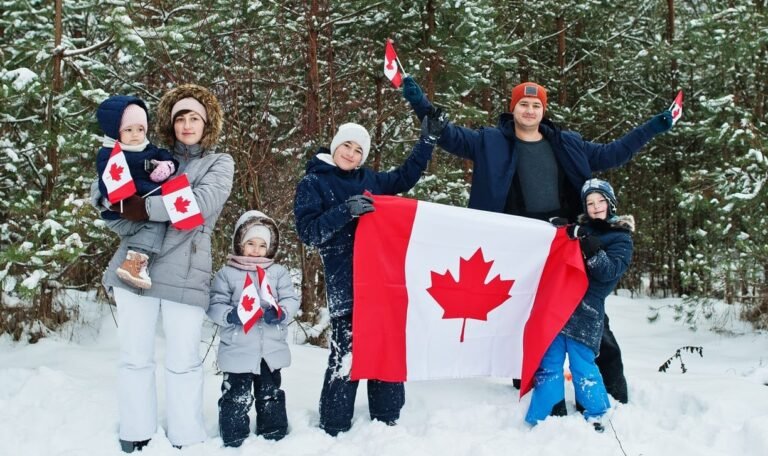 Family holding flag of Canada on winter landscape.