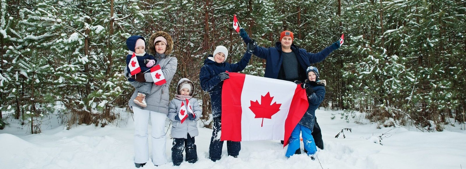 Family holding flag of Canada on winter landscape. Family holding flag of Canada on winter landscape.