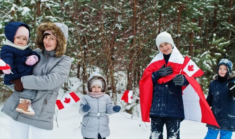 Mother with kids holding flag of Canada on winter landscape.