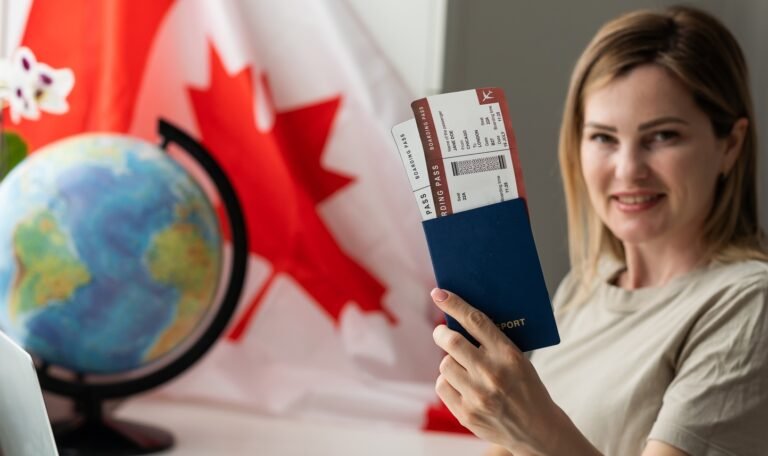 female student sitting with canadian flag and using laptop