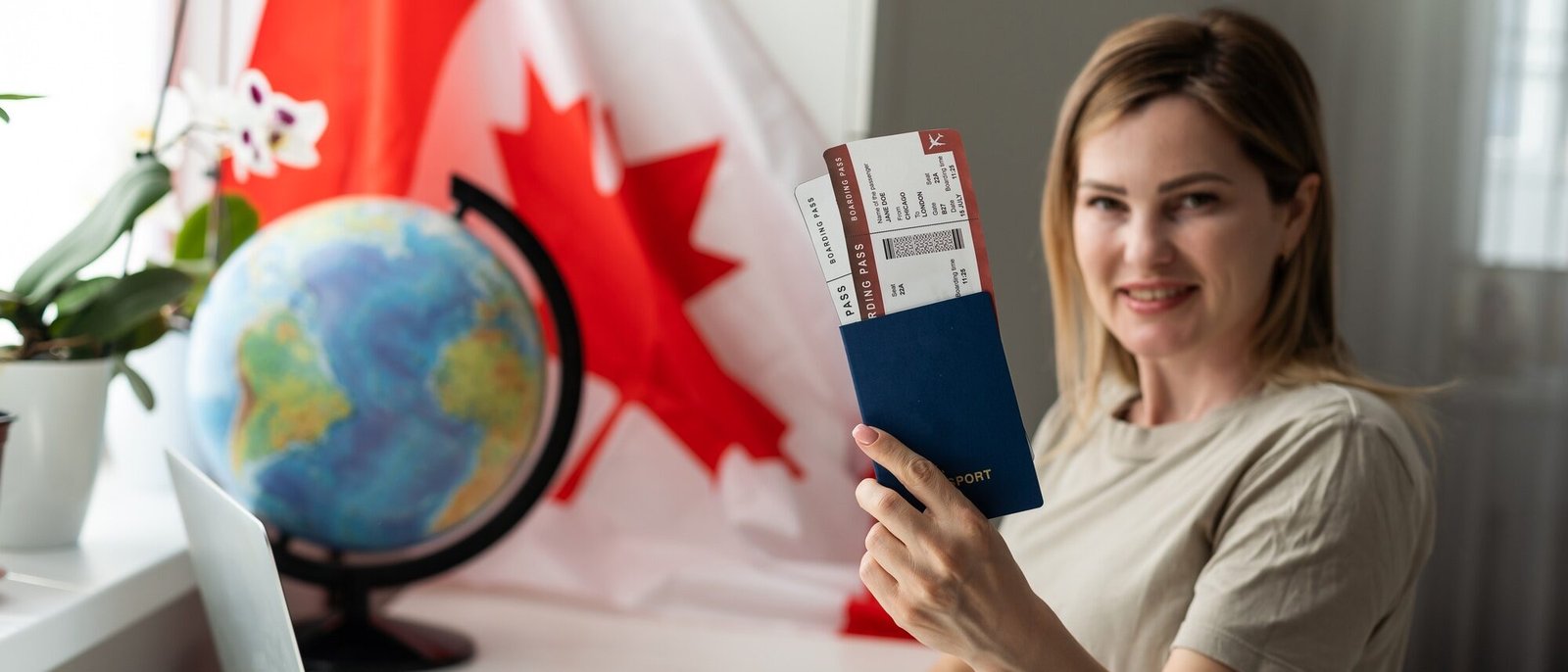 female student sitting with canadian flag and using laptop