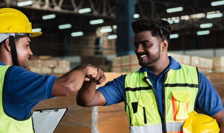 Group warehouse workers shake hands to celebrate and be happy in the warehouse.